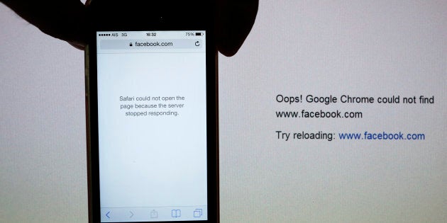 A mobile phone is held in front of a computer screen with both browsers unable to connect to Facebook via local providers in Bangkok May 28, 2014. Thai Facebook users were alarmed on Wednesday when the Information Communications Technology (ICT) Ministry blocked access to the site at the request of the military, but the junta blamed the brief shutdown on a technical problem. REUTERS/Damir Sagolj (THAILAND - Tags: SOCIETY POLITICS SCIENCE TECHNOLOGY)