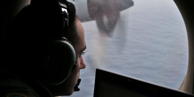 Flight officer Rayan Gharazeddine looks out of a Royal Australian Air Force (RAAF) AP-3C Orion as it flies over the southern Indian Ocean during the search for missing Malaysian Airlines flight MH370 March 22, 2014. REUTERS/Rob Griffith/Pool/File Photo
