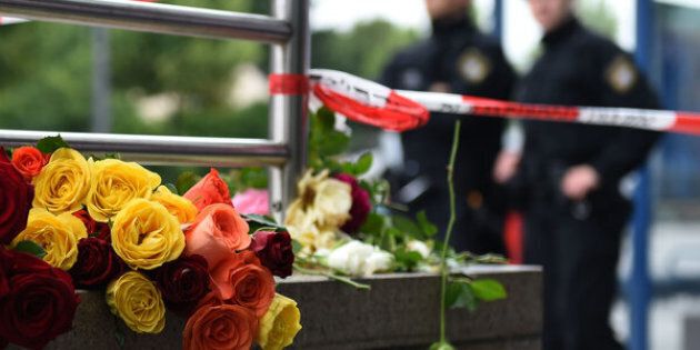 Police officers stand near flowers commemorating victims at the entrance of the subway station near the shopping mall Olympia Einkaufzentrum OEZ in Munich on July 23, 2016, a day after a gunman went on a shooting rampage, killing eight people in a suspected terror attack. The southern city was in lockdown after the shootings, which saw panicked shoppers fleeing the Olympia mall as armed anti-terror police roamed the streets in search of assailant. / AFP / Christof Stache (Photo credit should read CHRISTOF STACHE/AFP/Getty Images)