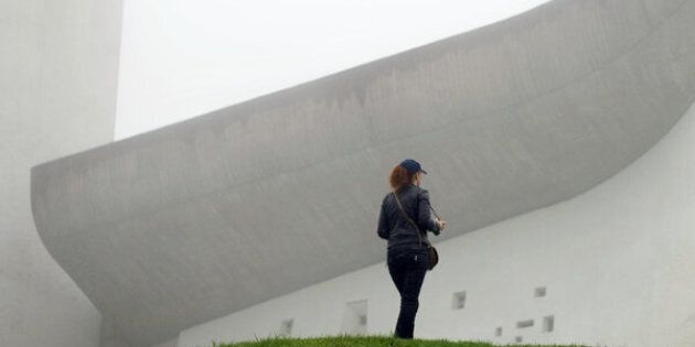 A visitor stands in front of Le Corbusier's Notre Dame du Haut chapel on Sept. 9, 2011, in Ronchamp, France. The chapel is one of the architect's most beloved buildings.