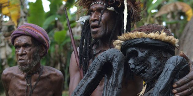 This photo taken on Aug. 7, 2016, shows Eli Mabel of the Dani tribe holding the mummified remains of his ancestor, Agat Mamete Mabel, in the village of Wogi in Wamena, the long-isolated home of the Dani high in the Papuan central highlands.