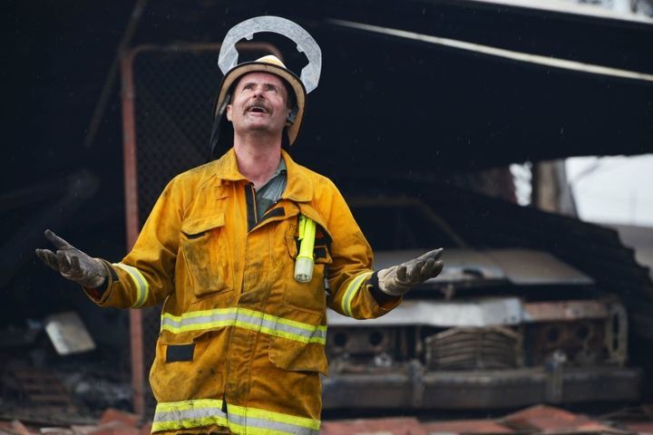 A Country Fire Service volunteer revels in the rain after bushfires in the Adelaide Hills in January, 2015.