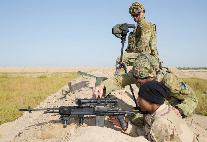 Australian Army soldier Corporal John Hatch (top) supervises as Private Lyndon Edwards adjusts the sights for at Iraqi Army soldier during marksmanship training at the Taji Military Complex in Iraq.