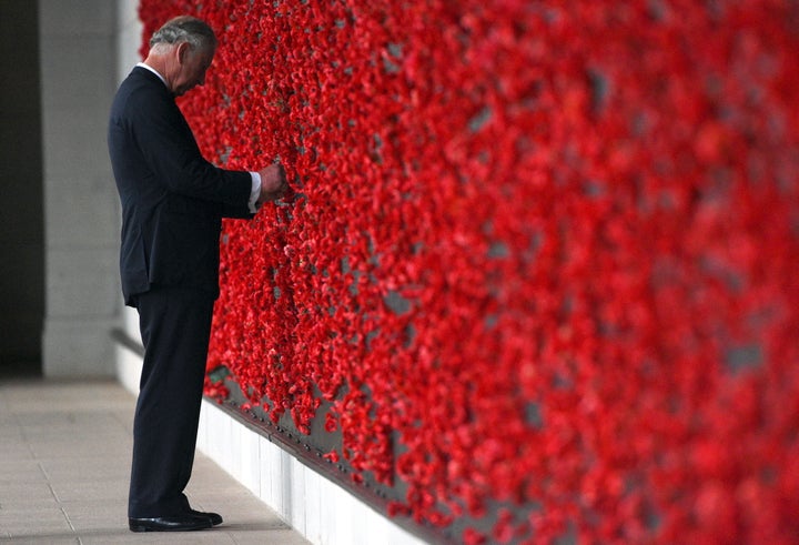 Prince Charles placing a poppy onto the Roll of Honour wall during the 2015 Remembrance Day ceremony at the Australian War Memorial in Canberra.