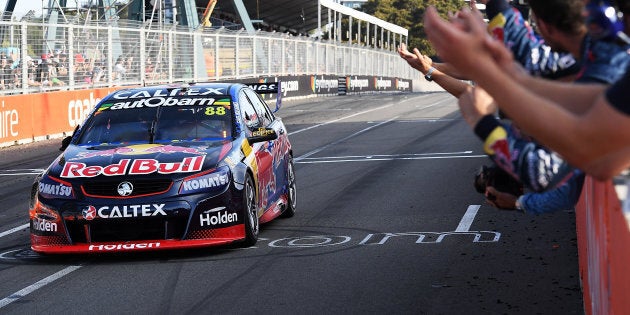 Jamie Whincup drives the #88 Red Bull Racing Australia Holden Commodore VF crosses the finish line to win race 28 for the Sydney 500.