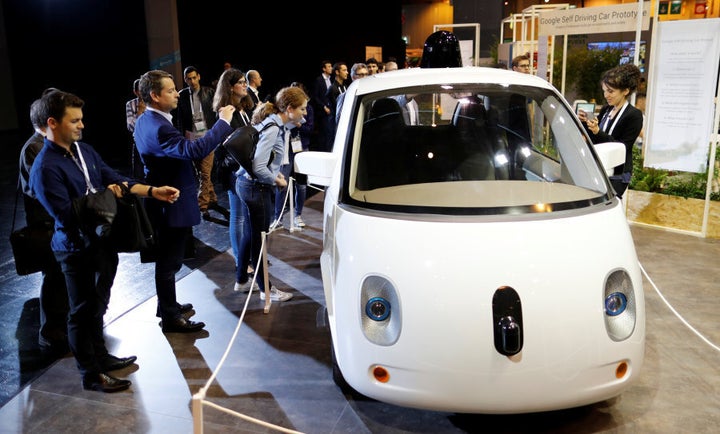 Visitors look at a self-driving car by Google displayed at the Viva Technology event in Paris in 2016.