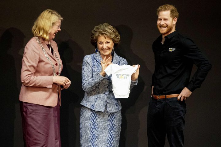 Netherlands' Princess Margriet (center) holds a piece of baby clothing next to Britain's Prince Harry (right) during the presentation of The Invictus Games The Hague 2020 in on Thursday.