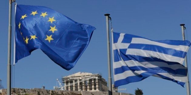 The Greek, right, and the European flags wave under the ancient Acropolis hill in Athens, Sunday, July 5, 2015. Greeks lined up at polling stations and ATMs alike Sunday as the country voted on its financial future, choosing in a referendum whether to accept creditors' demands for more austerity in return for rescue loans or defiantly reject the deal. (AP Photo/Petr David Josek)