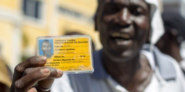 A Haitian sugar cane worker shows an identity card as he takes part in a march towards Haitian embassy in Santo Domingo, demanding Haitian passports needed to regularize their migration status in the Dominican Republic, on October 30, 2014. AFP PHOTO/Erika SANTELICES (Photo credit should read ERIKA SANTELICES/AFP/Getty Images)