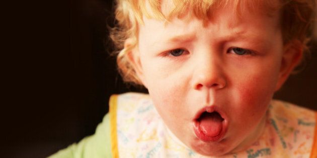 A young boy (18 months) with a nasty cough, coughing with his mouth open and tongue poking out