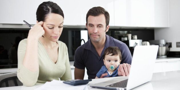 A couple and their baby son looking at their household finances