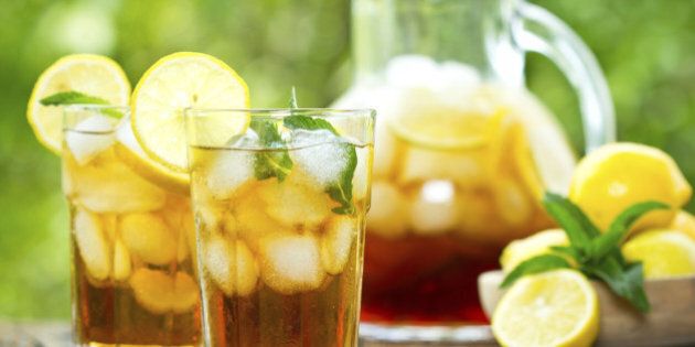 Two glasses with iced tea with lemon and ice on the wooden table