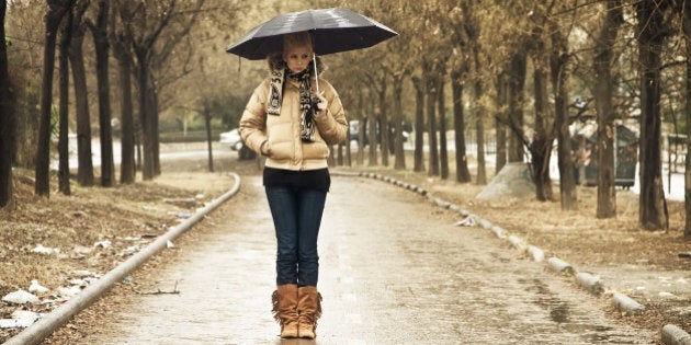 Young blond in walkway under rain