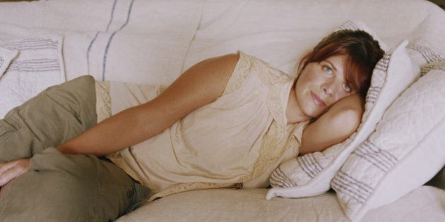 Sad woman lying on couch