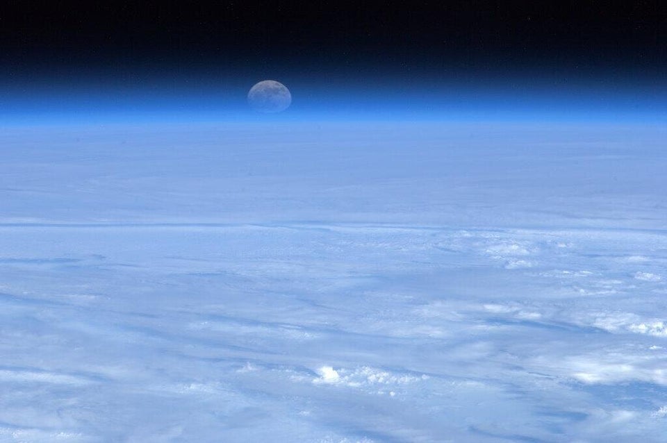 The moon rising over a bed of cloud