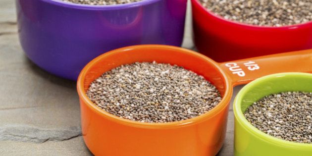 chia seeds in colorful measuring cups against slate rock background