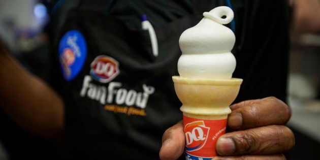 A Dairy Queen employee displays an ice cream cone for a photograph at a DQ Grill & Chill restaurant ahead of its grand opening in the Manhattan borough of New York, U.S., on Wednesday, May 28, 2014. Dairy Queen, the fast-food chain owned by Warren Buffett's Berkshire Hathaway Inc., is scheduled to open it's first ever location in Manhattan on Thursday, May 29. Photographer: Michael Nagle/Bloomberg via Getty Images