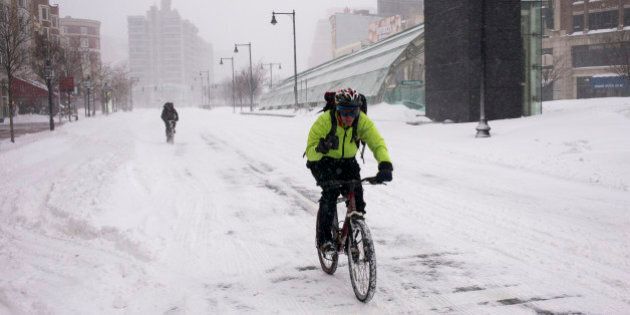 BOSTON, MA - JANUARY 27: Two bicyclists travel over snow January 27, 2015 along an empty Commonwealth Avenue in Boston, Massachusetts. Public transportation in Boston has been shut down due to a heavy snow storm with blizzard conditions set to leave over two feet of snow. (Photo by Robert Nickelsberg/Getty Images)
