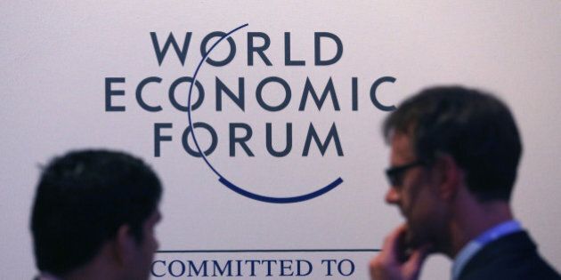 Attendees pass a World Economic Forum logo as they walk through the Kongress Zentrum, or Congress Center, during a break in sessions on day three of the World Economic Forum (WEF) in Davos, Switzerland, on Friday, Jan. 23, 2015. World leaders, influential executives, bankers and policy makers attend the 45th annual meeting of the World Economic Forum in Davos from Jan. 21-24. Photographer: Chris Ratcliffe/Bloomberg via Getty Images