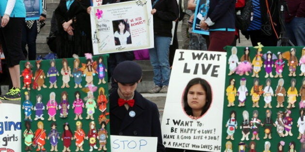 Participants take part in a rally on Parliament Hill in Ottawa on Friday, October 4, 2013 by the Native Women's Assoiciation of Canada honouring the lives of missing and murdered Aboriginal women and girls. THE CANADIAN PRESS/Fred Chartrand