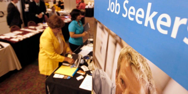 In this Tuesday, July 10, 2012 photo, people walk by the recruiters at a jobs fair in the Pittsburgh suburb of Green Tree, Pa. The number of people seeking unemployment benefits plunged last week to the lowest level in four years, a hopeful sign for the struggling job market. But the decline was partly due to temporary factors. (AP Photo/Keith Srakocic)