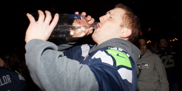 SEATTLE, WA - FEBRUARY 2: A Seattle Seahawks fan celebrates by drinking vodka straight out of the bottle after watching his team win the Super Bowl on February 2, 2014 in Seattle, Washington. The Seahawks defeated the Denver Broncos 43-8 in Super Bowl XLVIII. (Photo by David Ryder/Getty Images)