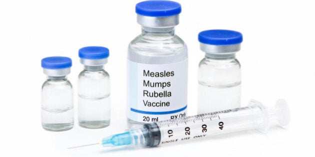 Measles, mumps, rubella, virus vaccine vials and syringe on white background. Label is fictitious, and any resemblance to any actual product is purely coincidental.