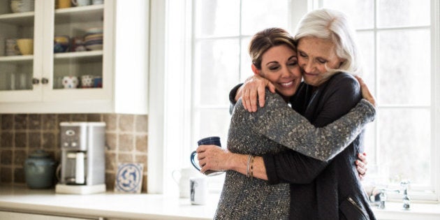 mother and daughter hugging in kitchen