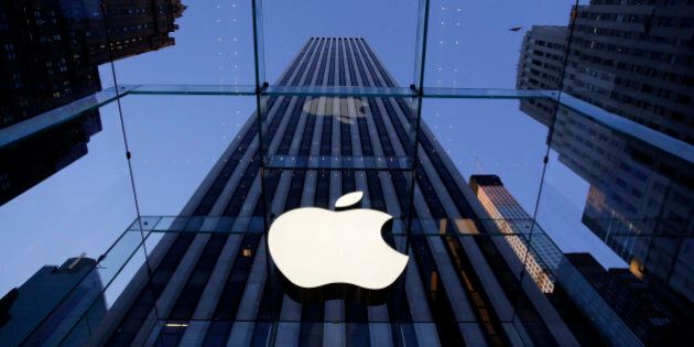 In this Sept. 5, 2014 photo, the Apple logo hangs in the glass box entrance to the company's Fifth Avenue store, in New York. Apple on Wednesday, Oct. 8, 2014 sent invites to an Oct. 16 event during which itâs expected to show off new models of its popular iPad and an update to its Mac OS system.(AP Photo/Mark Lennihan)