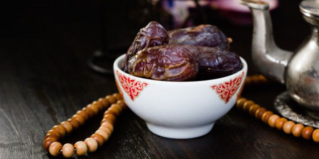 Ramadan fasting - dates for iftar in bowl on wooden table