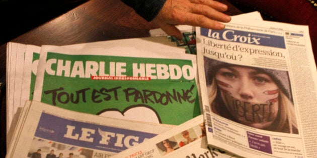 Copies of the latest issue of Charlie Hebdo newspaper are sold with other newspapers at a newsstand in Lille, northern France, Wednesday, Jan. 14, 2015. In an emotional act of defiance, Charlie Hebdo resurrected its irreverent and often provocative newspaper, featuring a caricature of the Prophet Muhammad on the cover that drew immediate criticism and threats of more violence. The black letters on the front page read: