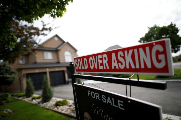 A real estate sign that reads "For Sale" and "Sold Above Asking" stands in front of housing in Vaughan, a suburb in Toronto, Canada, May 24, 2017. (Photo: Mark Blinch/Reuters)