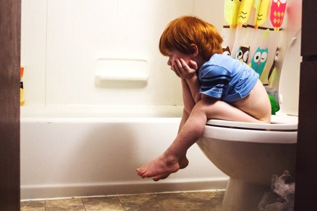 Young boy sitting on the toilet