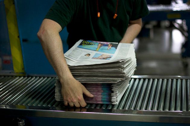 An employee stacks newspapers at the Toronto Star printing plant in Toronto, Ont., July 6, 2011.