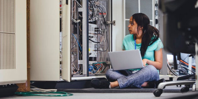 Female student checking on network servers using a laptop.