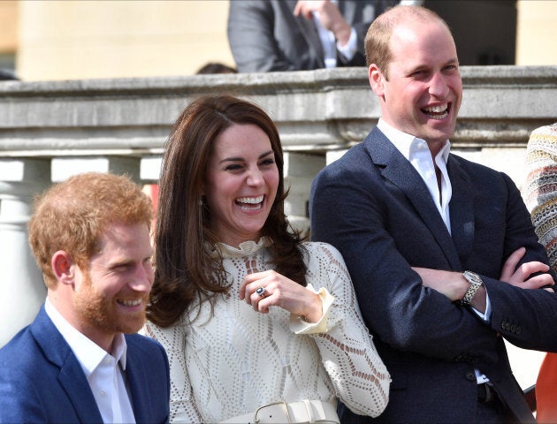 Prince Harry, Catherine, Duchess of Cambridge and Prince William, Duke of Cambridge laugh as they host a tea party in the grounds of Buckingham Palace.