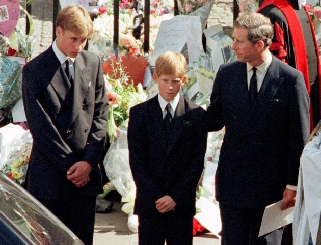 Prince Charles touches the shoulder of his son Harry as his other son Prince William watches the hearse bearing his mother Diana, Princess of Wales.