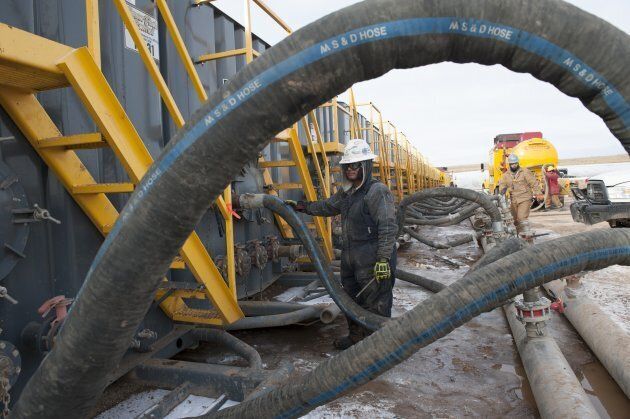 A worker monitors water tanks at a fracking site.