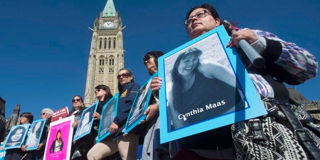 Women hold images of murdered and missing indigenous women during a rally for Missing and Murdered Indigenous Women on Parliament Hill in Ottawa, Tuesday October 4, 2016. THE CANADIAN PRESS/Adrian Wyld