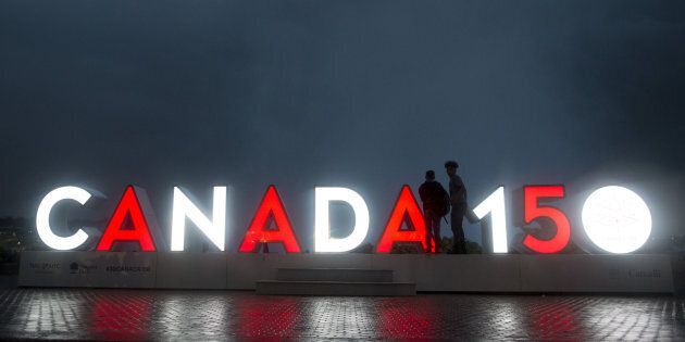 Tourists stand near an illuminated 'Canada 150' sign in Niagara Falls, Ontario, Canada, on Wednesday, June 21, 2017.