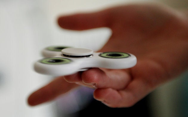 A girl plays with a fidget spinner toy in London, Britain, May 17, 2017.