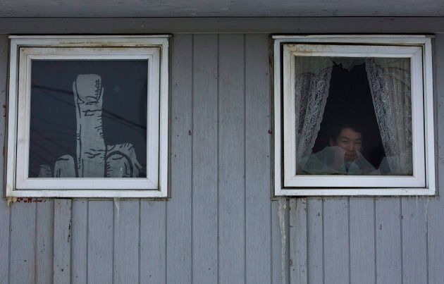 A Inuit person looks outside his window in Iqaluit in the Nunavut Territory of Canada on Wednesday, April 1, 2009. There are many people in Iqaluit who live in social housing. THE CANADIAN PRESS/Nathan Denette