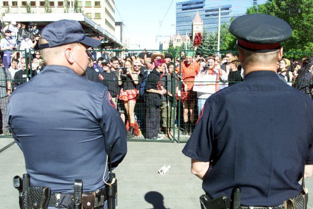 Calgary Police Service officers keep watch over protesters at an anti-World Petroleum Congress in Calgary June 11, 2000, Alta. (Photo: Jeff McIntosh/Newsmakers)