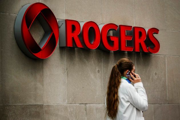 A woman speaks on her cell phone in front of a Rogers Communications Inc sign before the company's annual general meeting for shareholders in Toronto April 22, 2014.