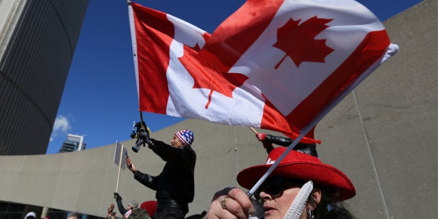 Opponents of the anti-Islamophobia federal government motion M-103 wave Canadian flags during a rally outside City Hall in Toronto, Ontario, Canada March 4, 2017.