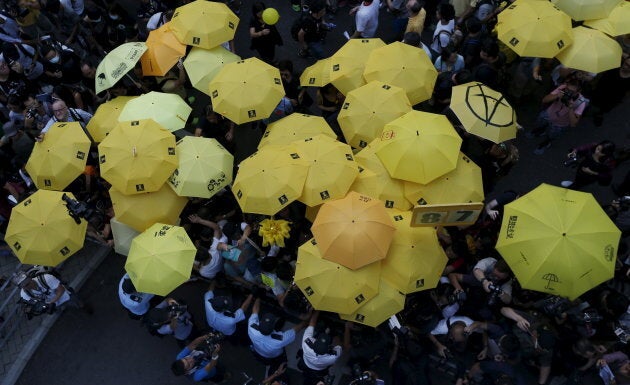 Pro-democracy protesters carrying yellow umbrellas, a symbol of the Occupy Central civil disobedience movement, are stopped by the police as they try to break the cordon line outside government headquarters in Hong Kong, China Sept. 28, 2015.