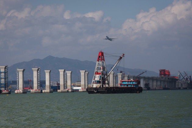 A transport barge travels past the Hong Kong-Zhuhai-Macau Bridge (HZMB) as it stands under construction in Hong Kong, China, on June 28, 2015.