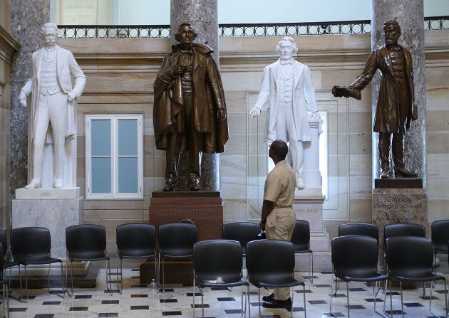 U.S. Navy Lt. William Edmund Newsome looks at a bronze statue of Confederate president Jefferson Davis (2ndL) that stands inside of Statuary Hall at the US Capitol June 24, 2015 in Washington, D.C. Some members of Congress are calling for the removal of the statue of the Confederate president from inside of the Capitol.