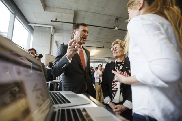 Bill Morneau, Canada's finance minister, centre left, speaks as Kathleen Wynne, premier of Ontario, center right, looks on during a demonstration at the MaRS Discovery District in Toronto, Ont. on March 30, 2017. A new institute for artificial intelligence research opened with funding from the federal and Ontario governments as well as the private sector.