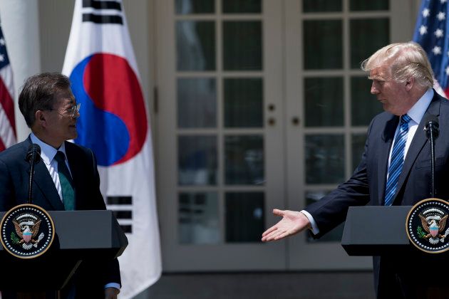 U.S. President Donald Trump reaches to shake the hand of South Korea's President Moon Jae-in after making a statement in the Rose Garden of the White House June 30, 2017 in Washington, DC.